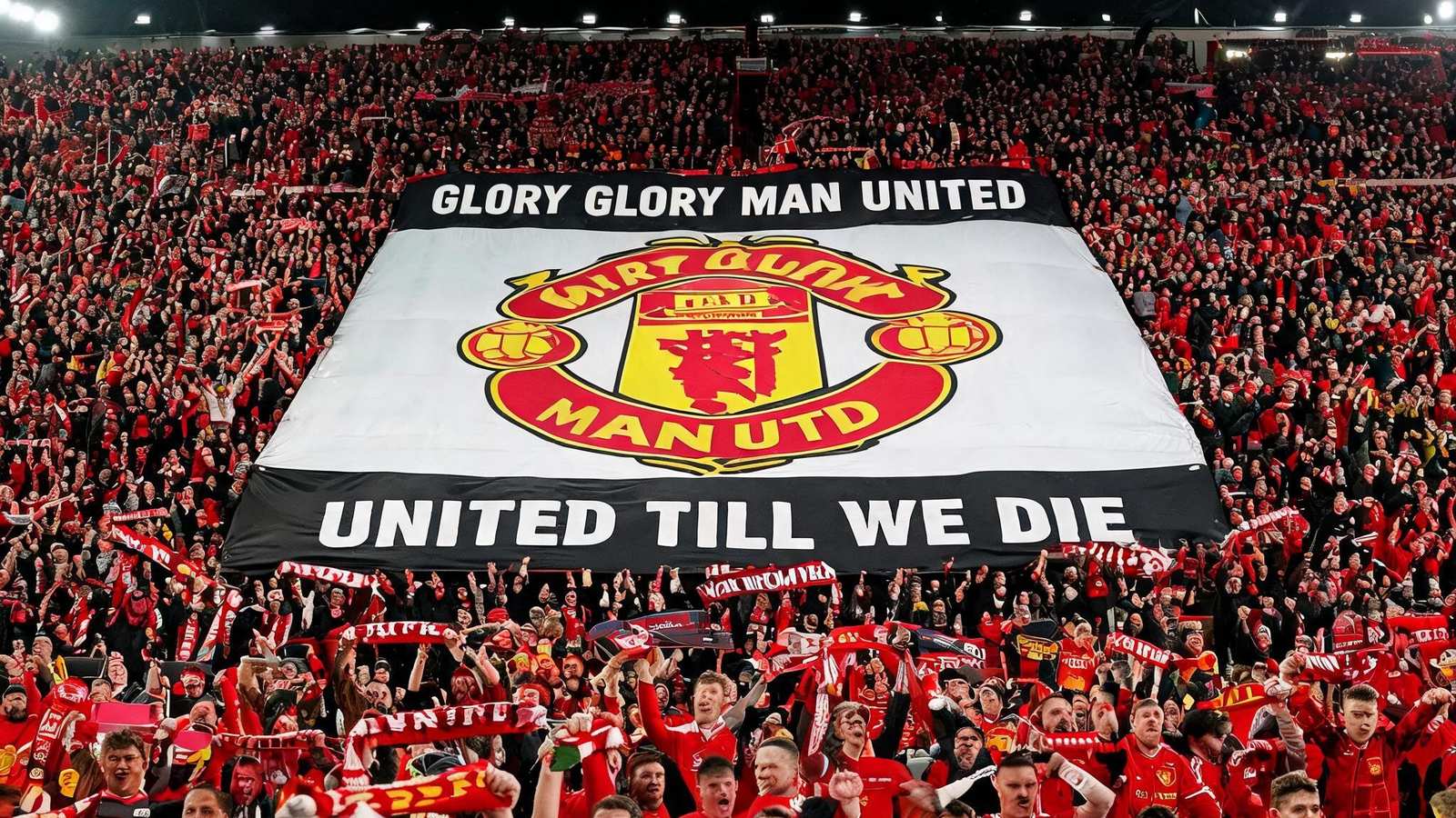 英超比赛日球迷在看台展示巨型TIFO，图案为俱乐部徽章与口号